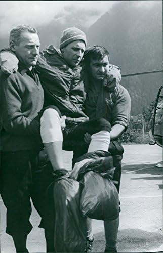 Vintage fotografija povrijeđenog čovjeka koje nose dvije osobe.